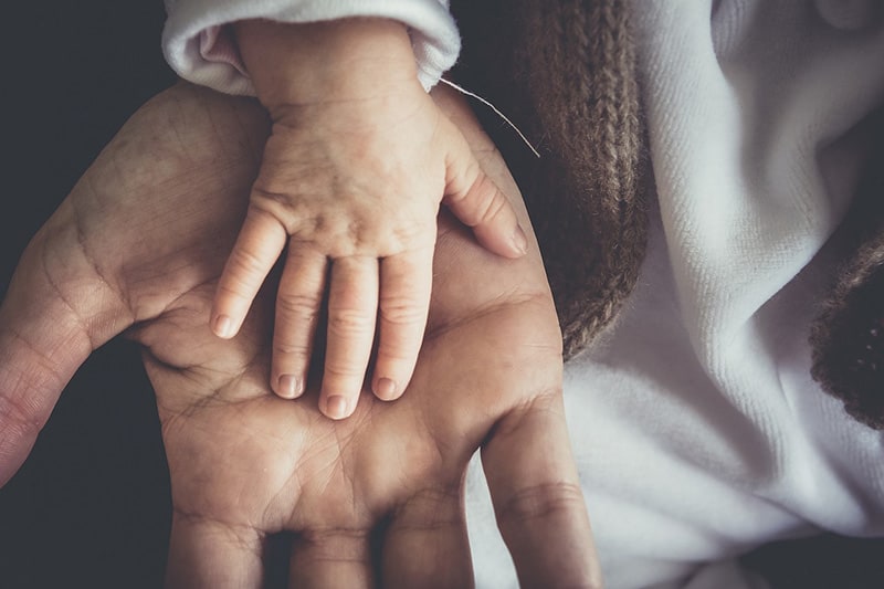 Child and adult hands volunteering for Home-Start